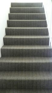 Front view of stairs with grey carpet flooring